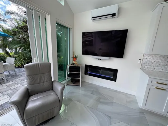 Living room with plenty of natural light, lofted ceiling, and a wall mounted air conditioner