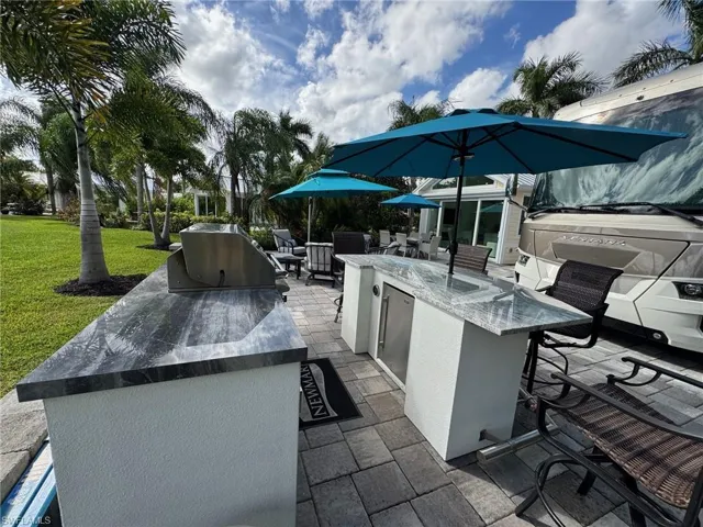 View of patio featuring a bar and an outdoor kitchen