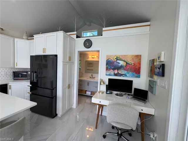 Office area featuring lofted ceiling with beams and sink