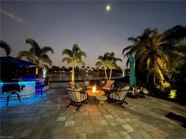 Patio terrace at dusk with a water view and an outdoor fire pit