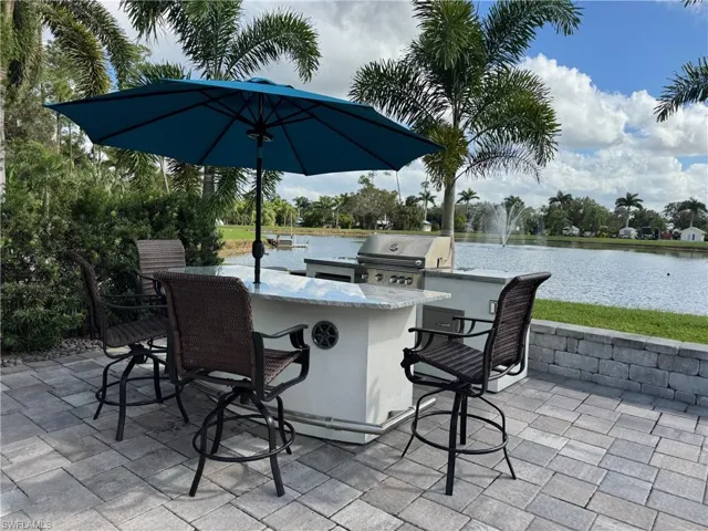 View of patio featuring a water view, area for grilling, and a bar