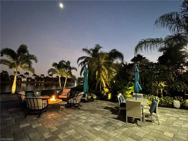 Patio terrace at dusk featuring an outdoor fire pit