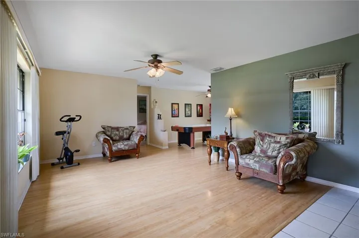 Living area featuring a ceiling fan, light wood-style floors, and pool table
