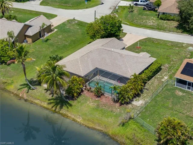 View from above of property with a nearby body of water and a pool area
