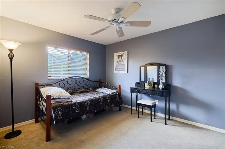 Carpeted bedroom featuring baseboards and ceiling fan