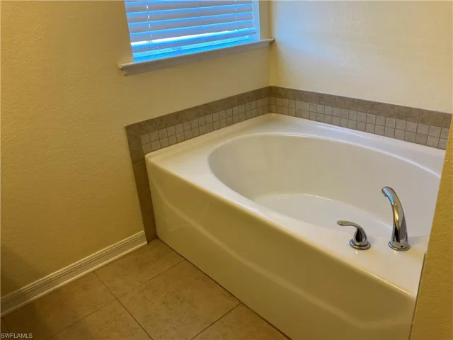 Bathroom with tile patterned flooring and a tub