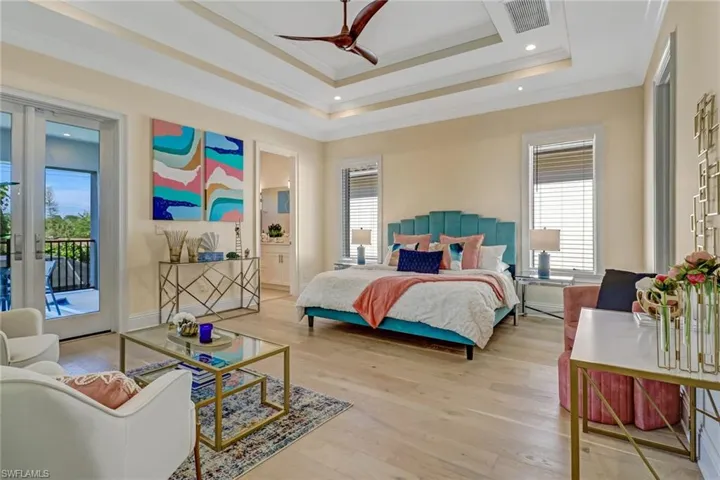 Bedroom featuring access to exterior, a tray ceiling, ceiling fan, crown molding, and light hardwood / wood-style flooring