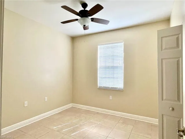 Tiled empty room featuring ceiling fan