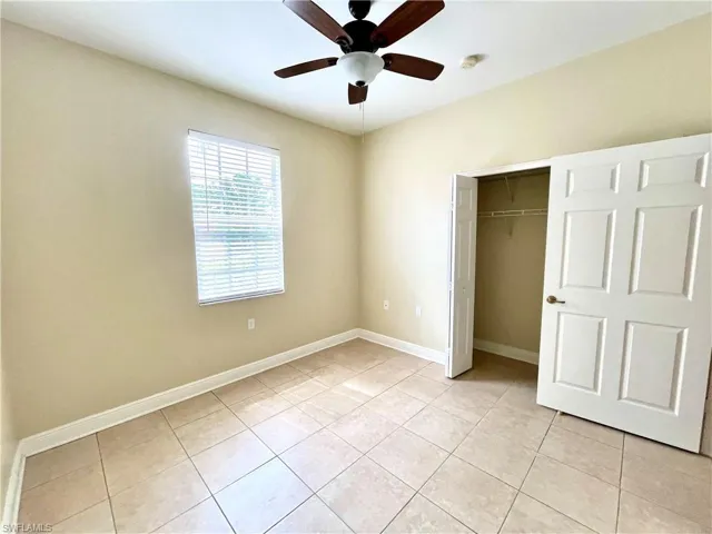Unfurnished bedroom featuring a closet, ceiling fan, and light tile patterned floors