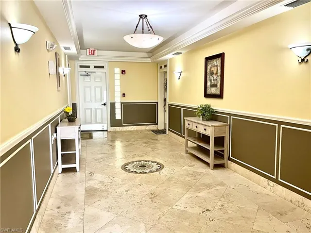 Foyer with a tray ceiling and crown molding