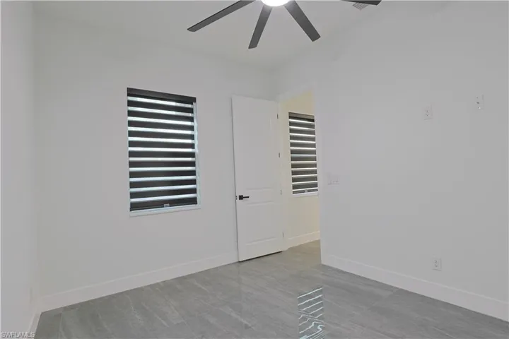 Unfurnished room with baseboards and a ceiling fan