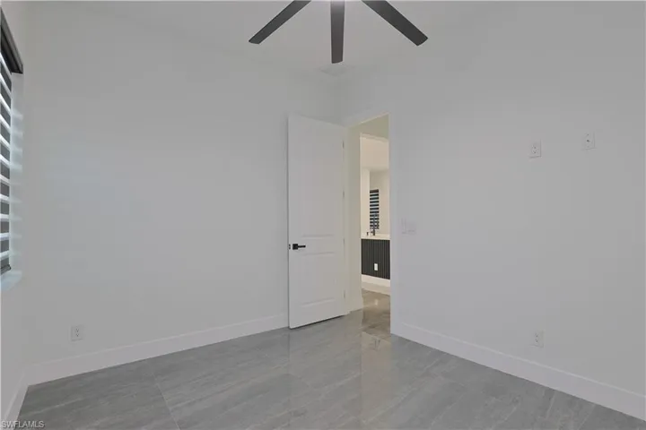 Unfurnished room with baseboards and a ceiling fan