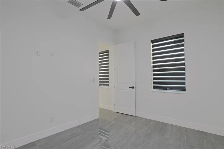 Empty room with baseboards and a ceiling fan