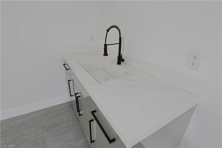 Kitchen view of light stone counters and white cabinets
