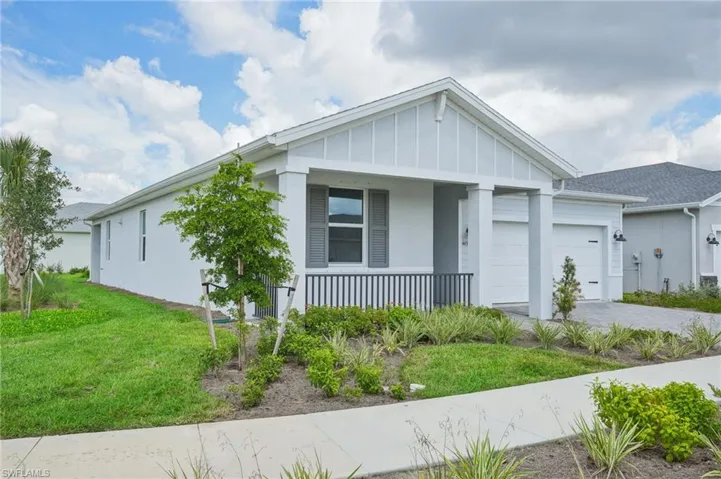 View of front of home featuring a porch, a garage, and a front yard