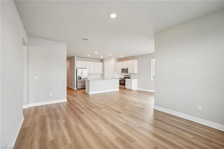 Unfurnished living room with sink and light hardwood / wood-style floors