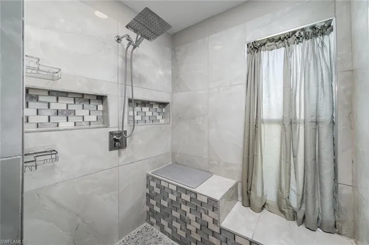 Bathroom featuring tile walls and tiled shower