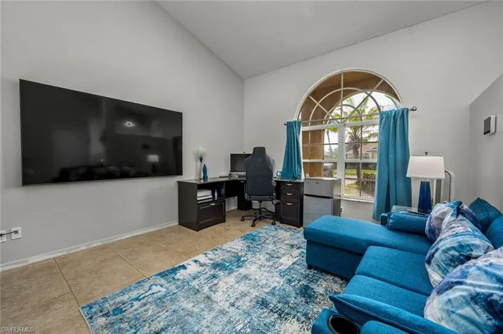 Office area featuring high vaulted ceiling and light tile patterned floors