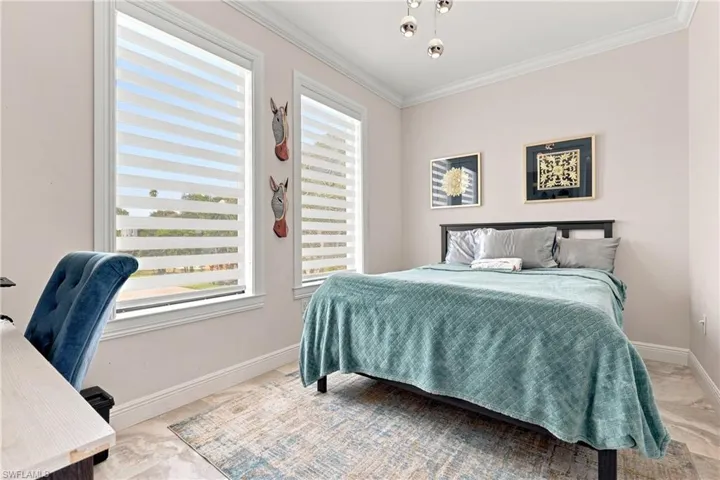 Dual windows with integrated blinds, crown molding, a modern ceiling light fixture, and tile flooring