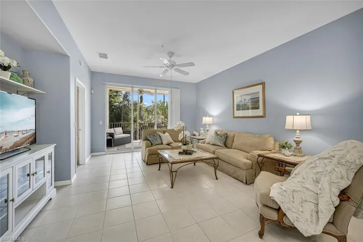 Living area with light tile patterned floors, baseboards, ceiling fan, and visible vents