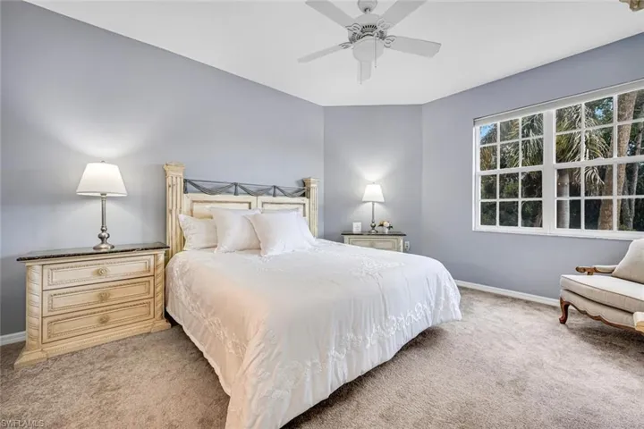 Bedroom with baseboards, a ceiling fan, and light carpet