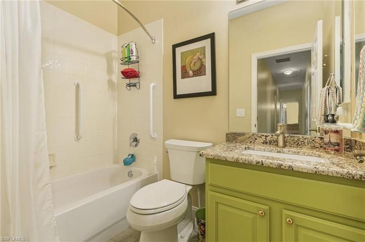 Spacious guest bedroom with new floors, plantation shutters, lighted ceiling fan.