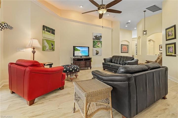 Spacious great room with lighted ceiling fan, cove lighting, new floors.