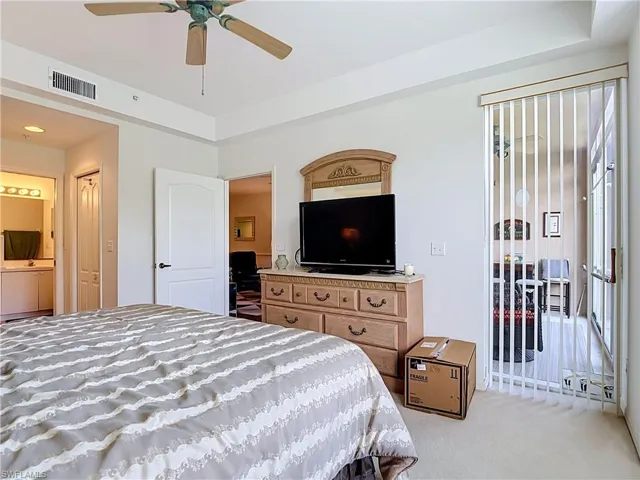 Recessed ceiling with a ceiling fan, white paneled doors, and a sliding glass door with vertical blinds
