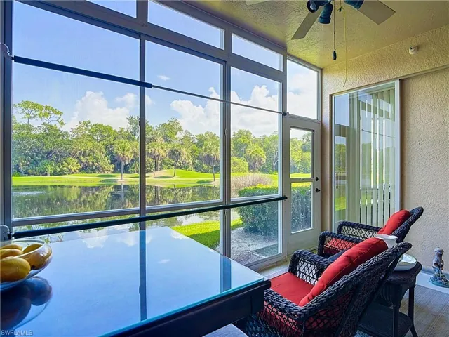 Enclosed lanai with extensive window panels overlooking a water feature and golf course