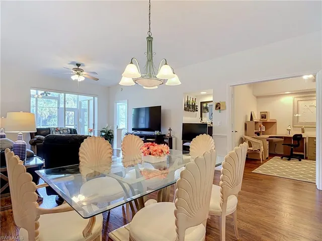 Hardwood-finish flooring, recessed lighting, and a chandelier in the dining area