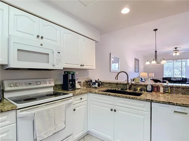 Kitchen featuring white cabinetry, granite-style countertops, a white electric range, a built-in microwave, and an undermount sink with a gooseneck faucet