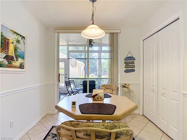 Recessed ceiling light fixture, bi-fold closet doors, tile flooring, chair rail molding, and a sliding glass door