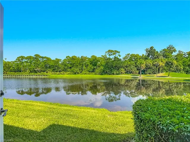 Expansive lake frontage with a manicured lawn and lush surrounding foliage