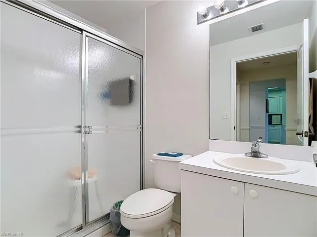 White vanity with integrated sink, chrome faucet, and mirrored medicine cabinet