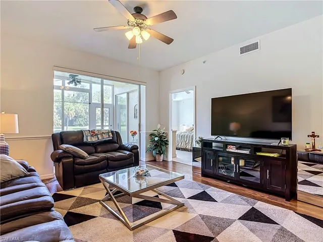 Screened-in patio with outdoor ceiling fan, wood-finish flooring, and a ceiling fan with integrated lighting