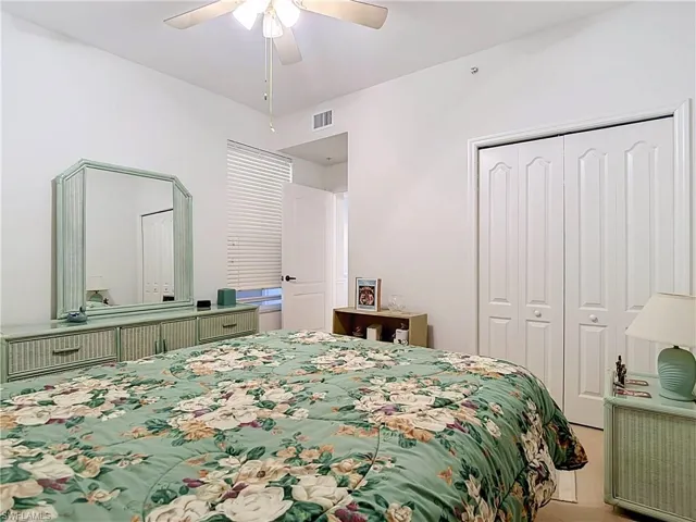 Ceiling fan with integrated lighting, white bi-fold closet doors, white interior door, and window with horizontal blinds