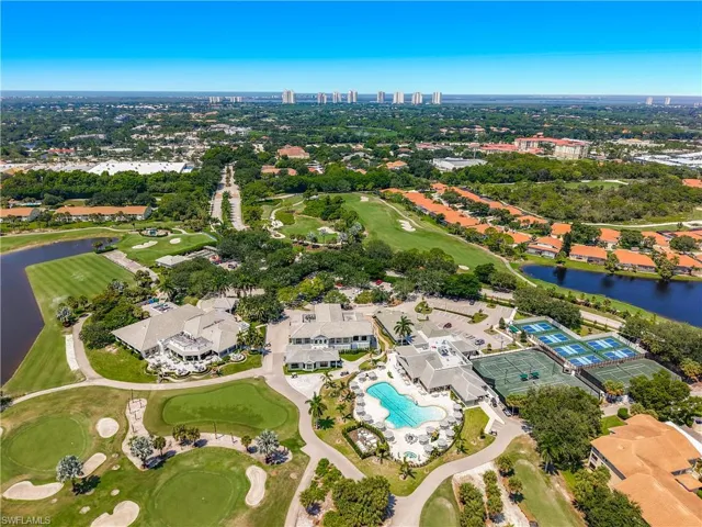 Expansive golf course with multiple greens, large clubhouse with exterior dining, resort-style swimming pool, and dedicated tennis court facility