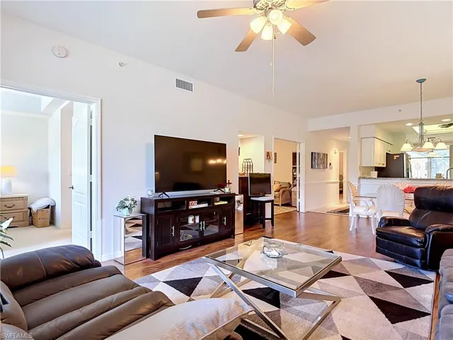 Hardwood-finish flooring, recessed ceiling fan, white paneled doors, and a built-in media console