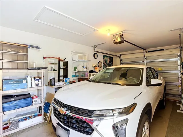 Attached garage with an overhead door opener and ceiling-mounted lighting