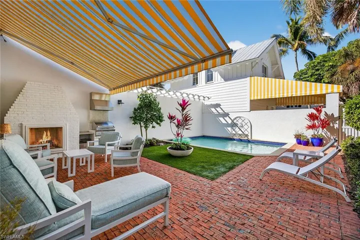 View of patio / terrace with a pergola, an outdoor pool, grilling area, and an outdoor brick fireplace