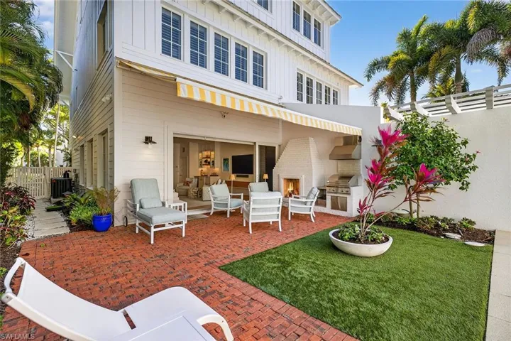 Rear view of house featuring board and batten siding, a patio area, and an outdoor kitchen