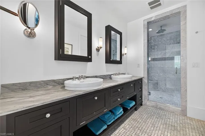 Master bathroom featuring double vanity and a shower stall