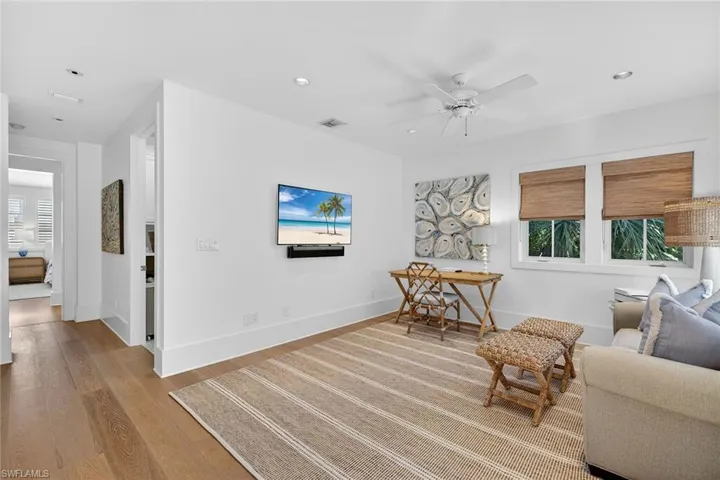 Den featuring light wood-style floors, a ceiling fan, and recessed lighting
