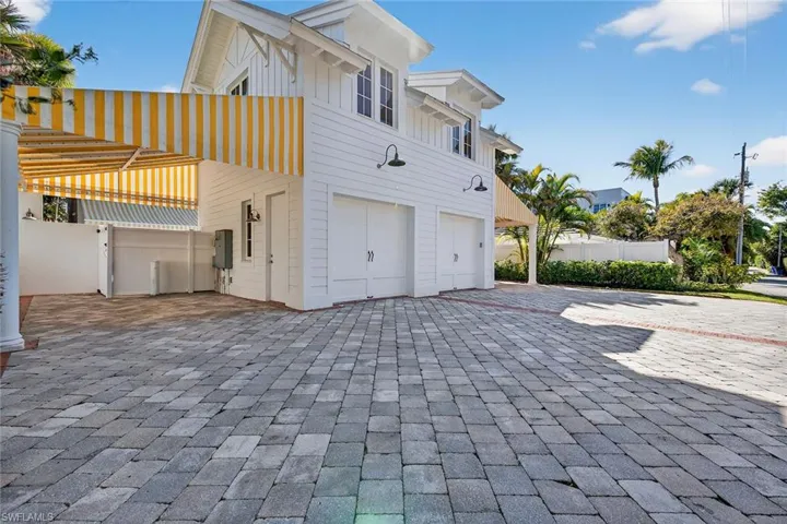 View of side of property with an attached garage, board and batten siding, and decorative driveway