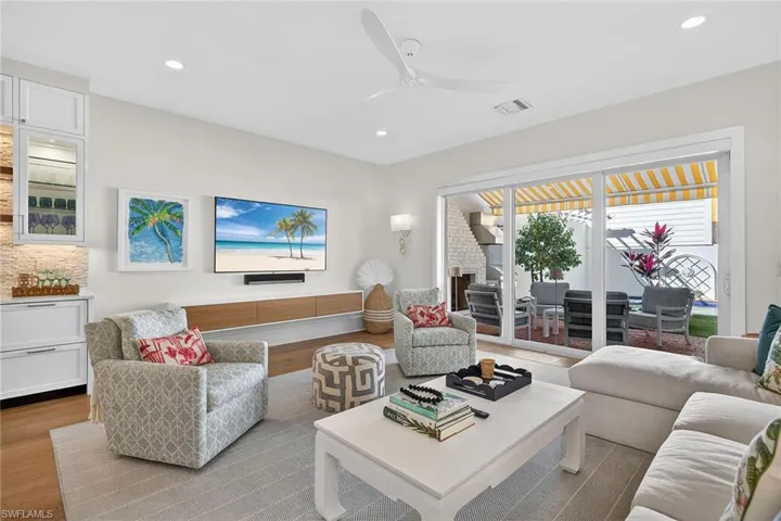 Living room with a ceiling fan, wood finished floors, and recessed lighting