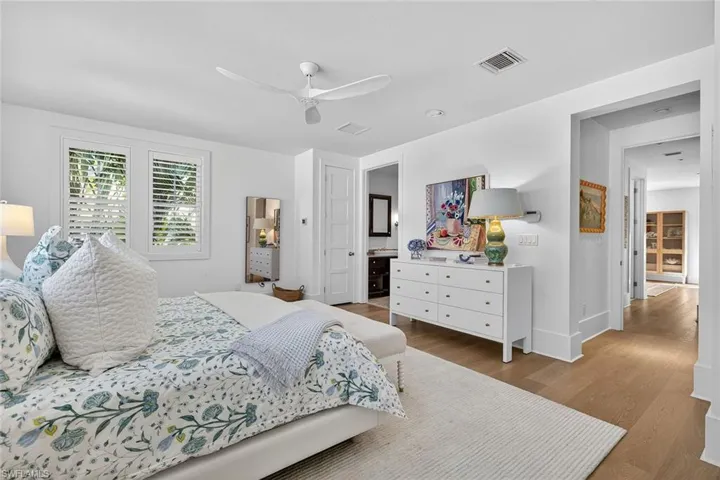Master bedroom with wood finished floors and ceiling fan
