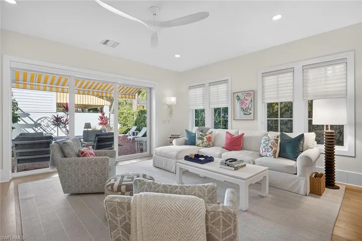 Living room featuring light wood-type flooring, a ceiling fan, recessed lighting, and healthy amount of natural light