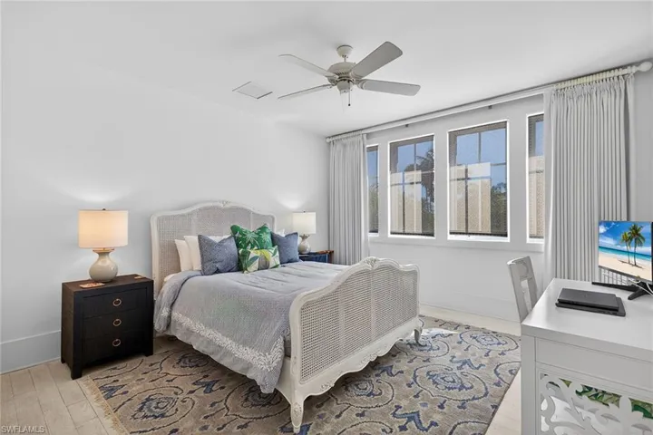 En-suite guest bedroom featuring ceiling fan and light wood-style floors