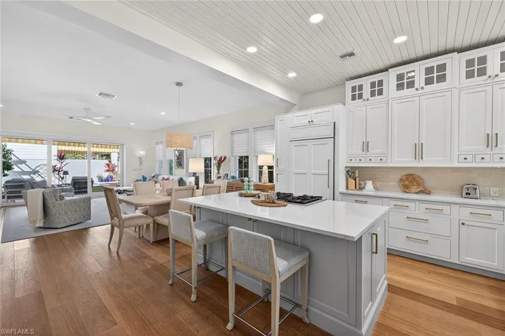 Kitchen with a kitchen breakfast bar, a kitchen island, white cabinetry, and light wood-type flooring