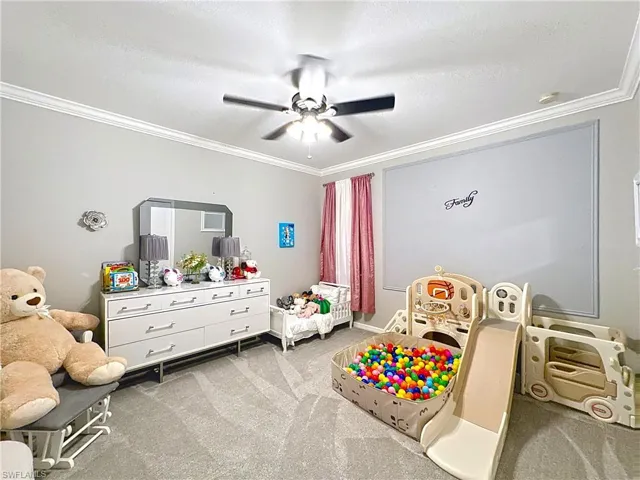 Bedroom featuring crown molding, carpet, and ceiling fan
